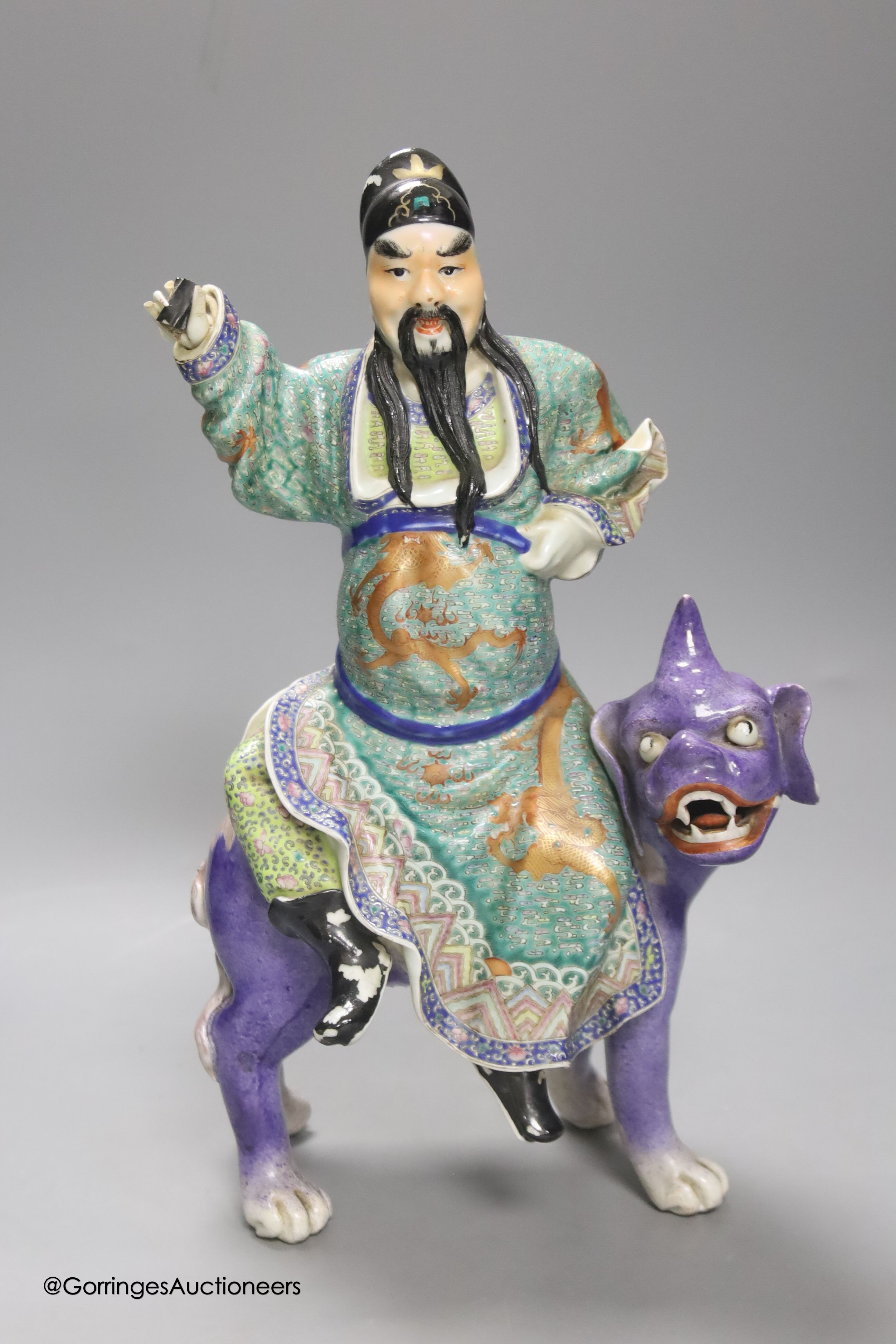 A Chinese enamelled porcelain figure group of an immortal on a mythical beast, Republic period, height 33cm